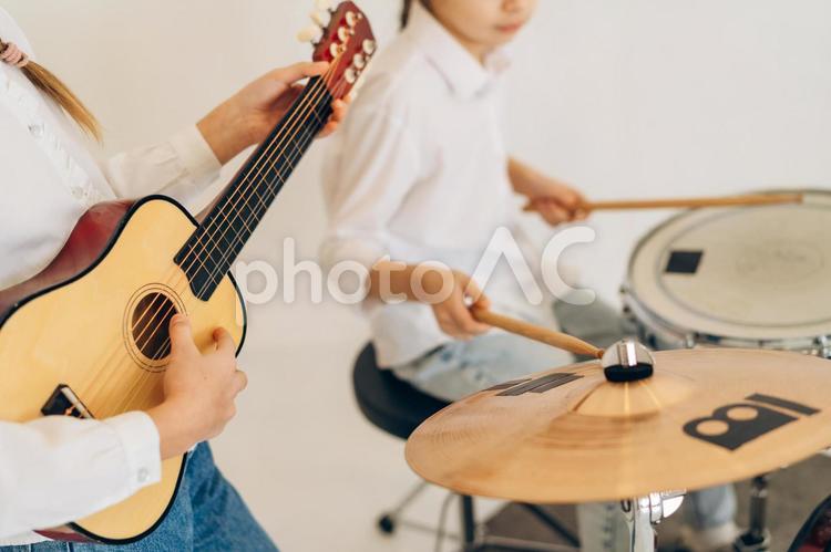 ギターを練習する人の手元とシンバルとスネアドラムを叩く女の子の鼻から下 鼻から下,手元,女の子の写真素材