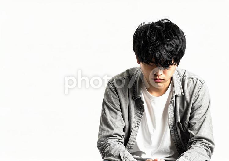 うつむいて悩む若い男性（白背景）01 男性,若者,うつむくの写真素材