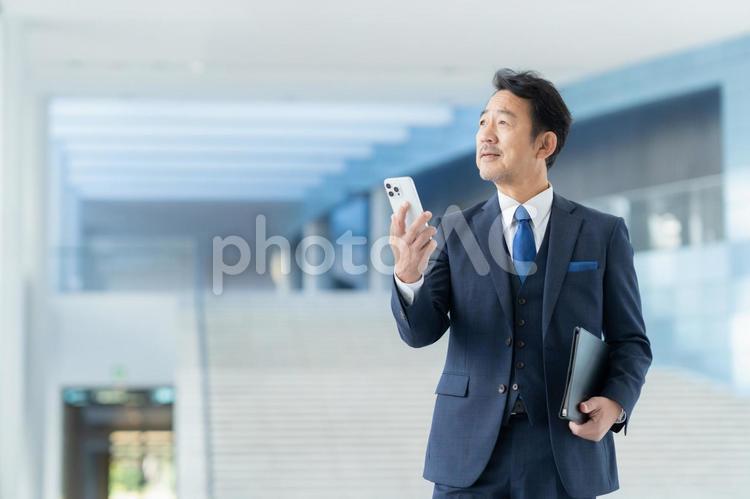 スマホを見る管理職のビジネスマン ビジネス,オフィス,スマホの写真素材