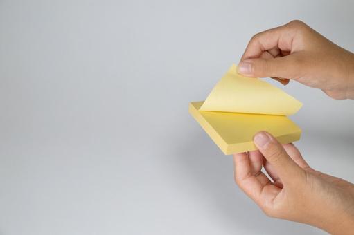 付箋を剥がす手とメモ帳 付箋,メモ,手の写真素材
