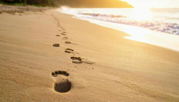 サンセットビーチに足跡のある夕暮れの写真