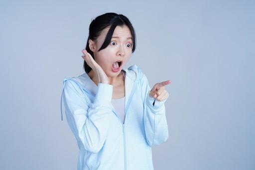 水色の服の女性が指を指して笑う 女性,指差し,驚くの写真素材