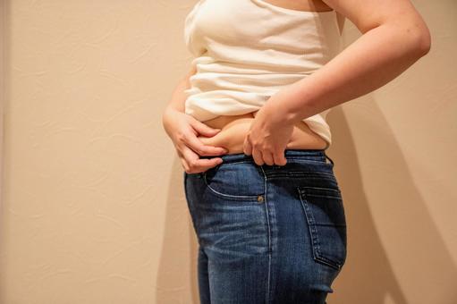 デニムパンツの上に乗るお腹の贅肉5 ダイエット,セルライト,脂肪燃焼の写真素材
