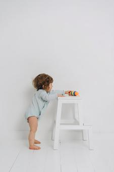 台の上の玩具を取ろうとしている横向きの子供 台の上の玩具を取ろうとしている横向きの子供 赤ちゃん,玩具,取るの写真素材