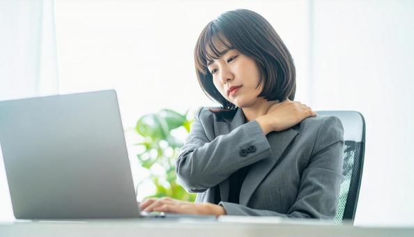 デスクワークで肩こりに悩むビジネスマン デスクワークで肩こりに悩むビジネスマンの写真