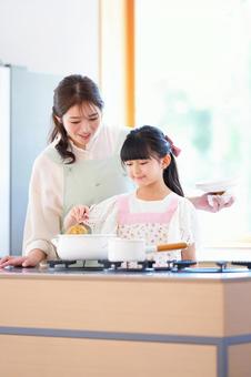 お玉で混ぜている女の子と母 お玉で混ぜている女の子と母 母,娘,女の子の写真素材