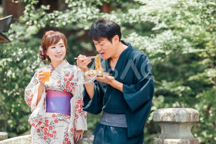 夏祭りにきてビールや焼きそばを食べる男女 夏祭り,縁日,たこ焼きの写真素材