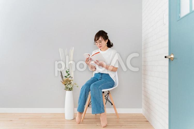 椅子に座って読書するアジア人女性 読書,漫画,本の写真素材