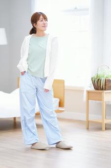 寝室で立ちポーズする女性の写真