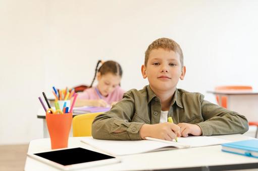 カメラ目線で勉強する生徒 男の子,女の子,子どもの写真素材