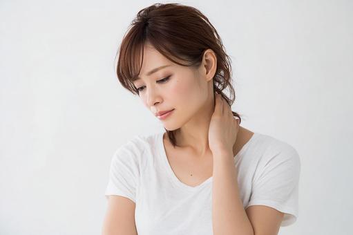 首の痛みに苦しむ疲労した日本人女性の写真