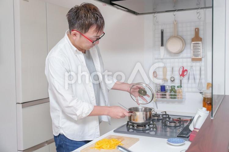 キッチンで鍋の蓋を開ける男性 キッチン,料理,男性の写真素材