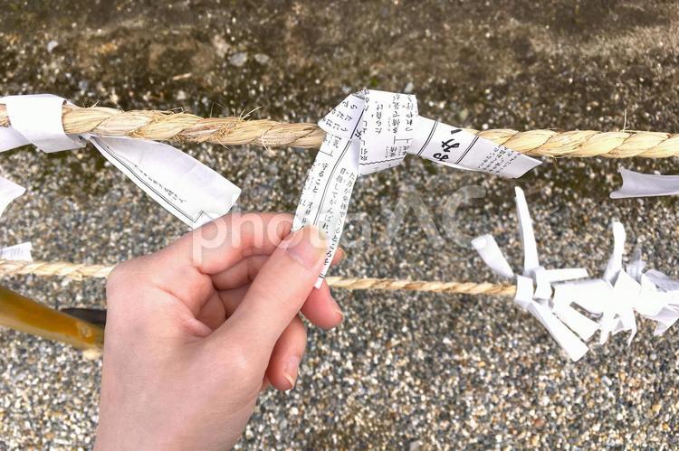 神社でおみくじを結ぶ手のイメージ おみくじ,結ぶ,手の写真素材