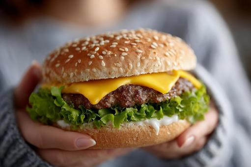 とろけるチーズが食欲をそそるハンバーガー とろけるチーズが食欲をそそるハンバーガーの写真
