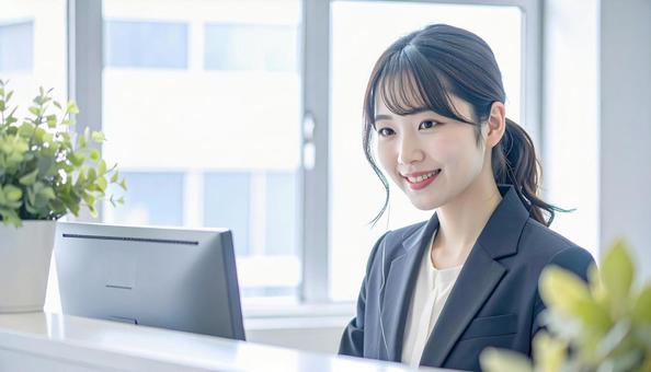 笑顔で対応する女性の受付嬢 笑顔で対応する女性の受付嬢の写真