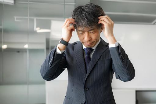 頭を抱えるビジネスマン 頭を抱えるビジネスマン 男性,スーツ,ネクタイの写真素材
