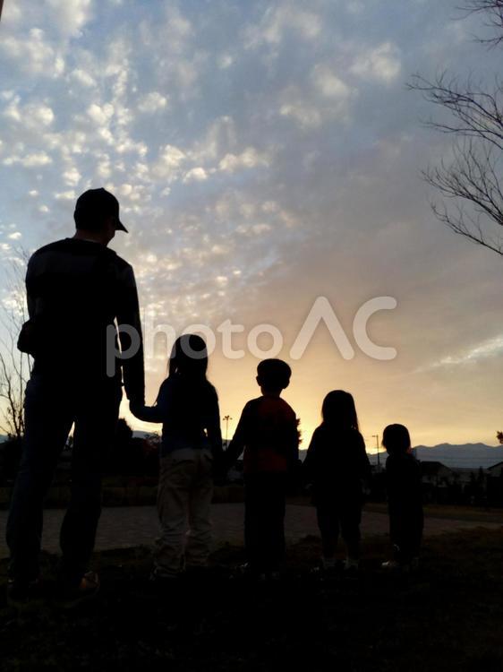 夕焼けと家族のシルエット シルエットで映す,子供,女の子の写真素材