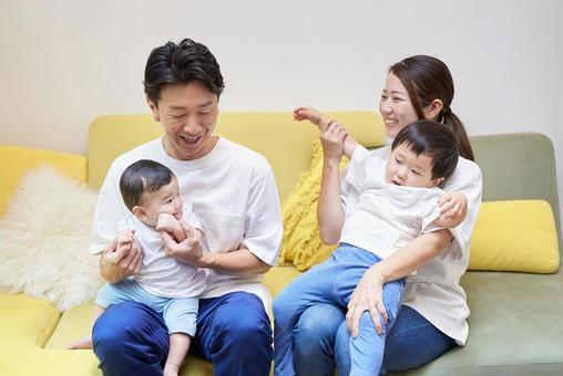 部屋のソファーでくつろぐ親子4人 部屋のソファーでくつろぐ親子4人 家族,育児,ファミリーの写真素材