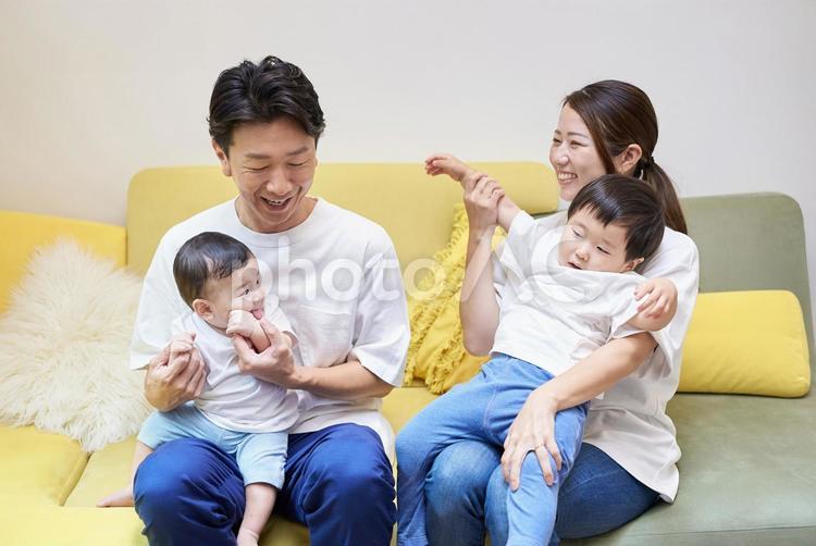 部屋のソファーでくつろぐ親子4人 家族,育児,ファミリーの写真素材