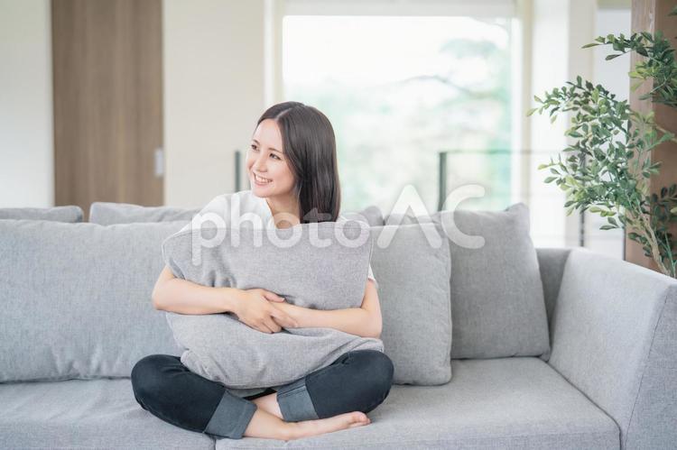ソファでくつろぐ女性 ソファ,女性,家の写真素材