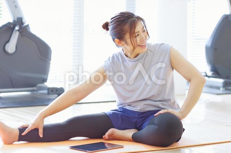 タブレットモニターを見ながら運動する女性 エクササイズ,体操,柔軟体操の写真素材