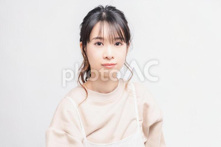 白い背景の前に立ってポーズをとる若い女性 女性,白背景,立つの写真素材
