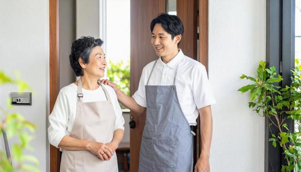見守り訪問で高齢者住宅を訪問する男性 見守り訪問で高齢者住宅を訪問する男性の写真