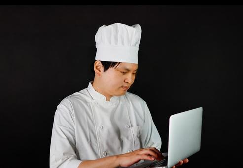 パソコン操作するシェフ シェフ,料理人,コックの写真素材