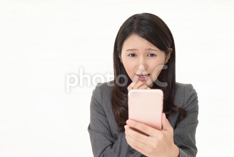 スマホの画面を見て驚く女性 女性,ビジネスウーマン,スマートフォンの写真素材