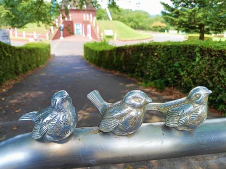 フェンスに留まるスズメのオブジェ フェンスに留まるスズメのオブジェの写真