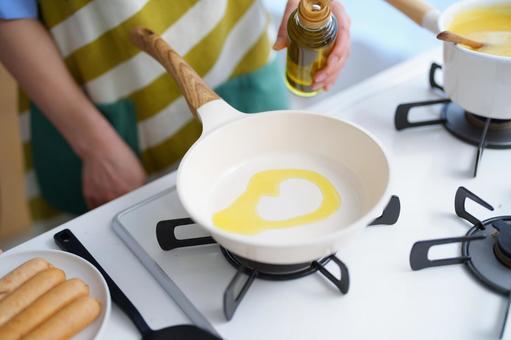 朝のキッチンで料理を楽しむひととき フライパン,オリーブオイル,油の写真素材