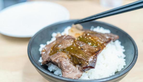 焼き肉を白ご飯に着けて食べる 焼き肉を白ご飯に着けて食べるの写真
