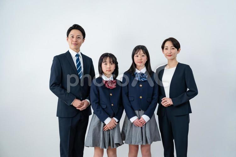 スーツを着た男女と制服を着た女の子二人 入学式,父母,母親の写真素材