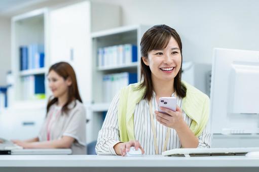 オフィスで働くビジネスウーマン オフィスで働くビジネスウーマン オフィス,スマホ,ビジネスウーマンの写真素材