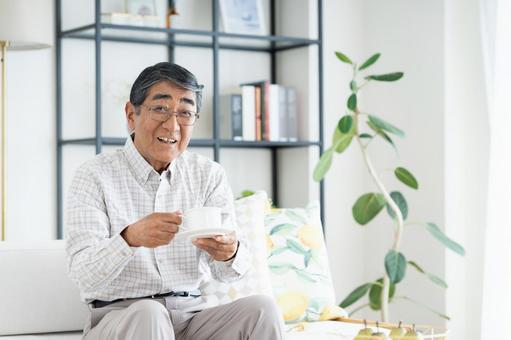 リビングでコーヒーを飲むシニアの男性 リビングでコーヒーを飲むシニアの男性 シニア,コーヒー,男性の写真素材