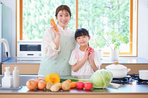 カメラ目線で野菜を持っている母子 カメラ目線で野菜を持っている母子の写真