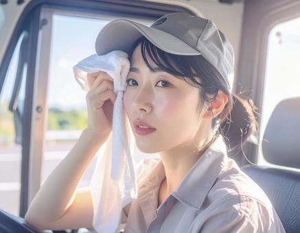 女性トラック運転手 休憩中 汗を拭く 女性トラック運転手 休憩中 汗を拭くの写真