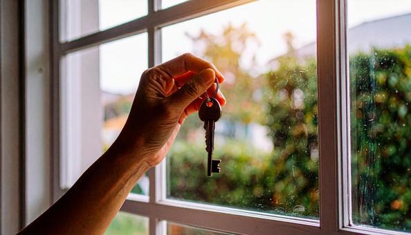 戸締り 家の鍵を持つ女性の手の写真