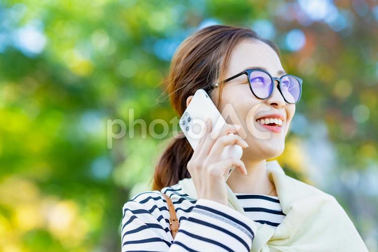 スマホで通話している笑顔の女性  女性,スマートフォン,30代の写真素材