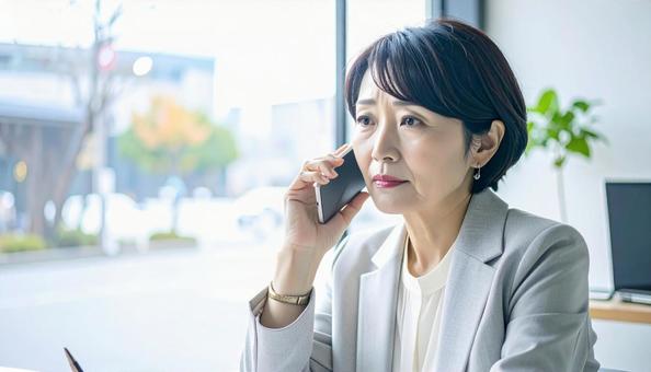 困った表情で電話する中年 困った表情で電話する中年の写真