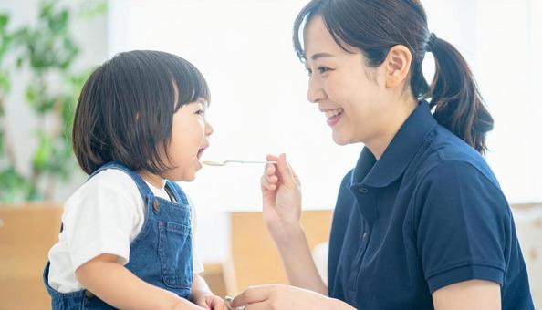 子どもにご飯をあげる保育士 子どもにご飯をあげる保育士の写真