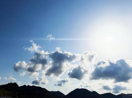 初夏の青空に浮かぶ雲と太陽の光 初夏の青空に浮かぶ雲と太陽の光の写真