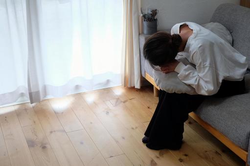 ソファーで悩む40代女性 女性,ショック,悩むの写真素材