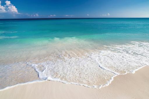 エメラルドグリーンの夏の海と白い波 エメラルドグリーンの夏の海と白い波の写真