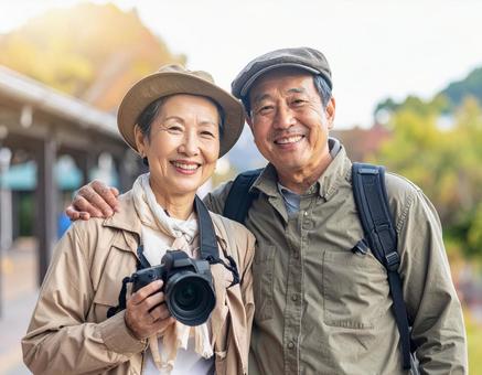 カメラを持って旅する仲良しシニア夫婦の写真