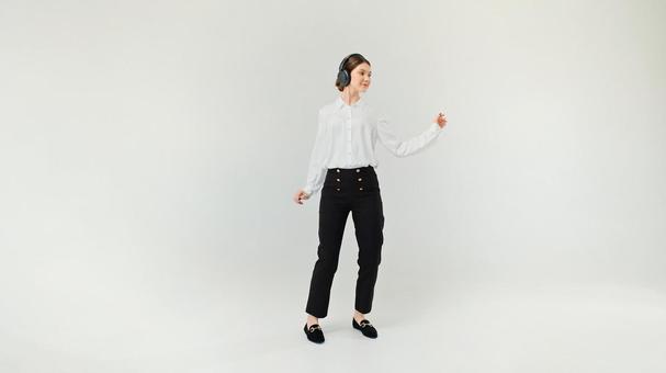 ヘッドホンで音楽を聴いている女性 ヘッドホンで音楽を聴いている女性の写真