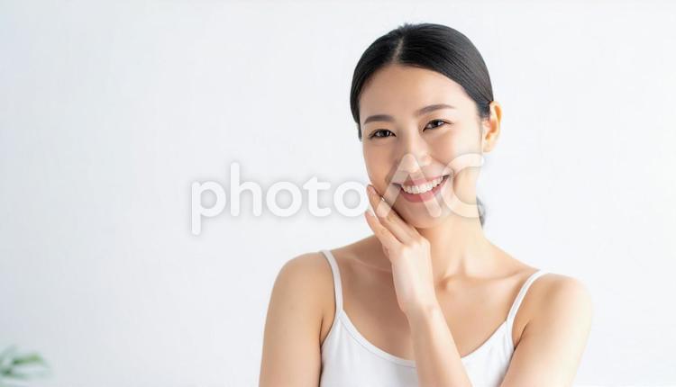 笑顔で頬に手を添える女性のポートレート 人物,女性,20代の写真素材