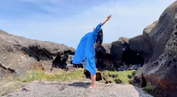 海でヨガをする女性の写真