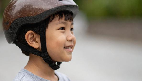 自転車用ヘルメットをかぶる男の子 自転車用ヘルメットをかぶる男の子の写真