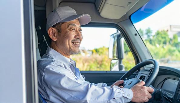 トラックを運転する男性ドライバーの横顔の写真